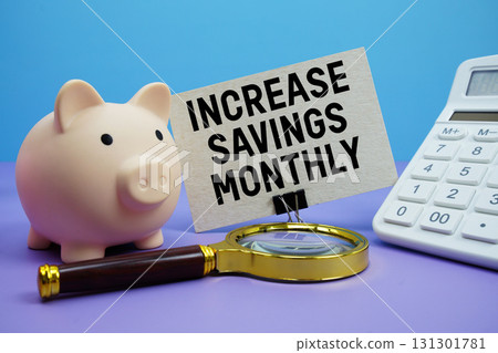 Increase Savings Monthly text with piggy bank, calculator and magnifying glass on blue and purple background 131301781