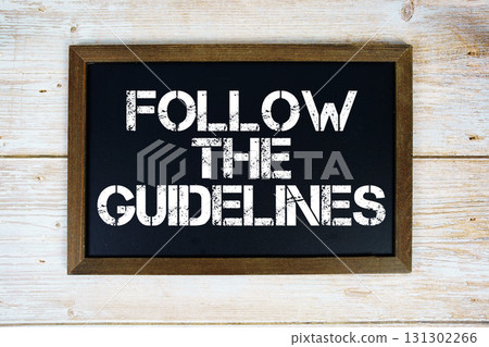 Follow the Guidelines text written on blackboard flat lay on wooden background 131302266