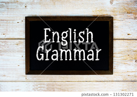 English Grammar text with gift box present and alarm clock on black background 131302271