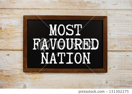 Most Favored Nation text with gift box present and alarm clock on black background 131302275