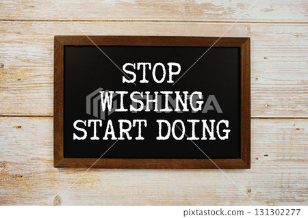Stop Wishing Start Doing text written on blackboard flat lay on wooden background 131302277
