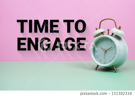 Black alarm clock on a pastel green and pink background with the text "Time to Engage" Black alarm clock on a pastel green and pink background with the text "Time to Engage" 131302338