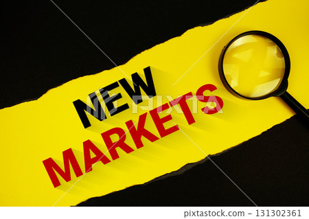 New Markets text on yellow with black paper torn ripped and magnifying glass 131302361