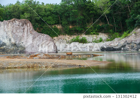 Scenic emerald pond with cliffs and reflection of trees. 131302412