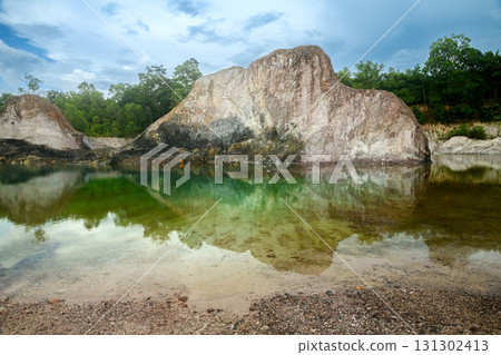 Scenic emerald pond with cliffs and reflection of trees. 131302413
