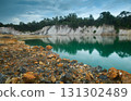 Abandoned quarry pond with rocky ground and turquoise water. 131302489
