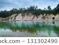 Abandoned quarry pond with turquoise water and trees. 131302490
