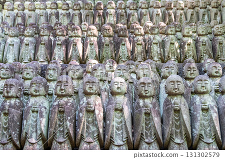 Rows of stone Buddha statues in outdoor temple garden for spiritual meditation at Kamakura, Kanagawa, Japan 131302579