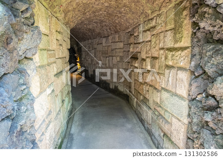 Stone tunnel corridor with textured walls and dim lighting at Kamakura, Kanagawa, Japan Stone tunnel corridor with textured walls and dim lighting at Kamakura, Kanagawa, Japan 131302586