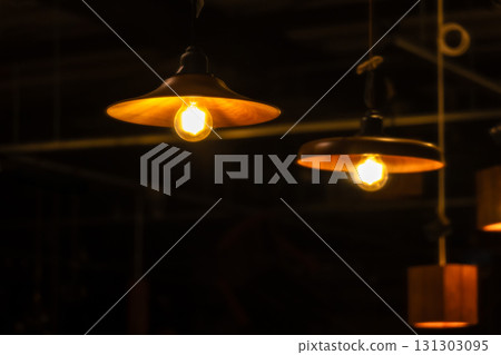 Antique-style pendant lights glow in the room at night 131303095