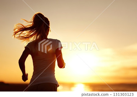 Silhouette of a young woman running on the beach during sunset. The vibrant hues of sunset create a magical atmosphere as the silhouette of a young woman runs along the shoreline. Silhouette of a young woman running on the beach during sunset. The vibrant hues of sunset create a magical atmosphere as the silhouette of a young woman runs along the shoreline. 131303123