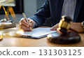 Cropped photo of a lawyer signing documents in court. The cropped view highlights the lawyer's hands, showcasing the significance of signing vital papers in the courtroom. 131303125