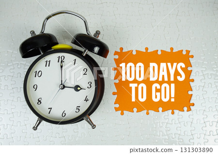 100 Days To Go! text with alarm clock on orange background 100 Days To Go! text with alarm clock on orange background 131303890