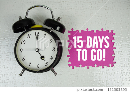 15 Days To Go! text with alarm clock on pink background 15 Days To Go! text with alarm clock on pink background 131303893