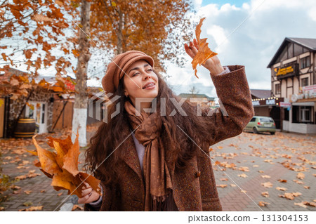 Autumn vibes and city stillness follow a fashionable young woman as she enjoys her weekend walk, breathing in the charm of golden leaves and urban elegance. Autumn vibes and city stillness follow a fashionable young woman as she enjoys her weekend walk, breathing in the charm of golden leaves and urban elegance. 131304153