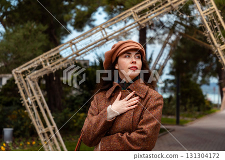 Portrait of stylish woman walks through the urban landscape in autumn, showing signs of calm and emotional distance. Portrait of stylish woman walks through the urban landscape in autumn, showing signs of calm and emotional distance. 131304172