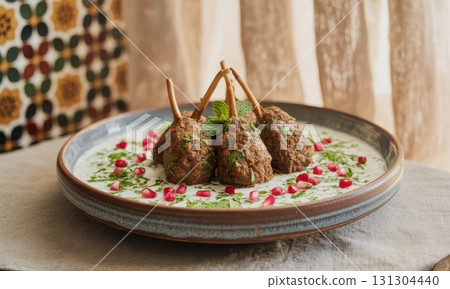 Delicious lamb kofta skewers with creamy yogurt sauce, mint, and pomegranate seeds 131304440