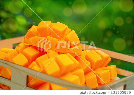 Cutted artificial fruits of orange ripe mango. There are multi-colored bokeh effect elements around the edges of the frame. Imitation of food, crop time, harvesting concept Cutted artificial fruits of orange ripe mango. There are multi-colored bokeh effect elements around the edges of the frame. Imitation of food, crop time, harvesting concept 131305939