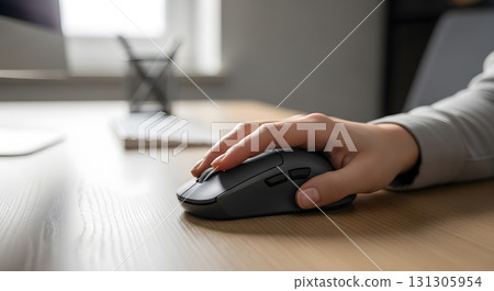 Hand Using Wireless Mouse on Wooden Desk in Office Setting. 131305954