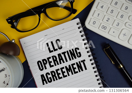 LLC Operating Agreement text written on notepad with calculator and alarm clock on navy blue background LLC Operating Agreement text written on notepad with calculator and alarm clock on navy blue background 131306564