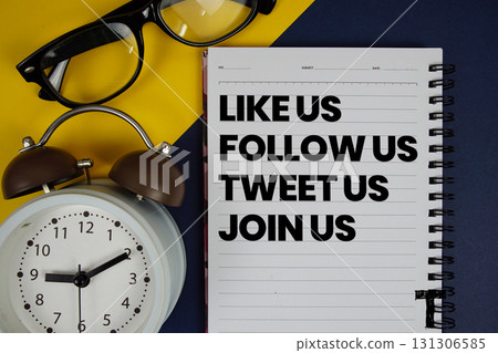 Like Us Follow Us Tweet Us Join Us text written on notepad with alarm clock on blue background 131306585