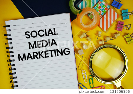 Social Media Marketing text with magnifying glass and stationery on yellow background Social Media Marketing text with magnifying glass and stationery on yellow background 131306596