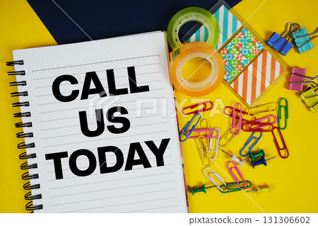 Call Us Today text with stationery on yellow background Call Us Today text with stationery on yellow background 131306602