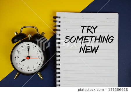 Try Something New text written on notepad with alarm clock on yellow background 131306618