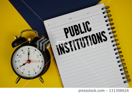 Public Institutions text written on notepad with alarm clock on yellow background Public Institutions text written on notepad with alarm clock on yellow background 131306626