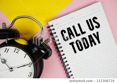 Call Us Today text written on notepad with alarm clock on pink background Call Us Today text written on notepad with alarm clock on pink background 131306719