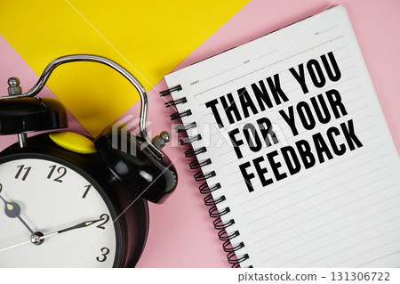 Thank you for your Feedback text written on notepad with alarm clock on pink background 131306722