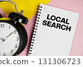 Local Search text written on notepad with alarm clock on pink background 131306723