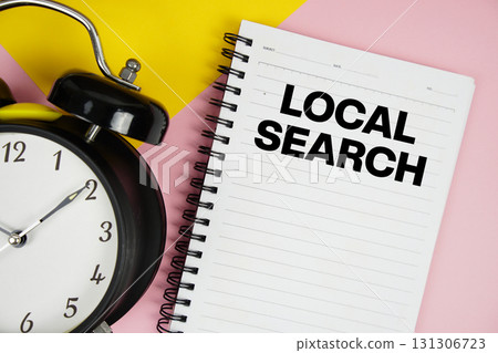 Local Search text written on notepad with alarm clock on pink background 131306723