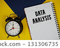 Data Analysis text written on notepad with alarm clock on yellow background 131306735