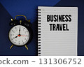 Business Travel text written on notepad with alarm clock on blue background 131306752