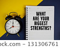 What Are Your Biggest Strengths? text written on notepad with alarm clock on yellow background 131306761