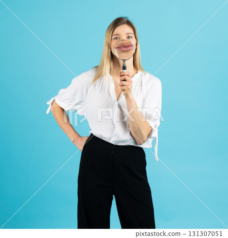 Studio portrait of woman with magnifying glass Studio portrait of woman with magnifying glass 131307051