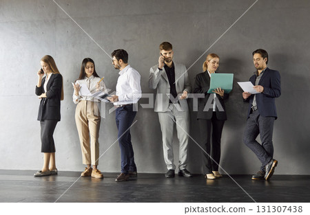 Portrait of confident business people in formal clothes talking on a meeting indoors. Portrait of confident business people in formal clothes talking on a meeting indoors. 131307438