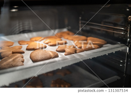 Deliciously spiced gingerbread cookies are baking in the warm oven, perfect for joyous holidays and celebrations Deliciously spiced gingerbread cookies are baking in the warm oven, perfect for joyous holidays and celebrations 131307534