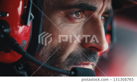 A focused close-up of a bearded man wearing red headphones with a microphone 131308765