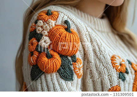Golden Hour Knitting. Crochet details of pumpkin pattern on a modern garment. Autumn atmosphere in clothes. Trending in fashion. 131309501
