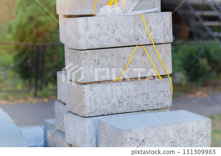 Stacked sidewalk paving stones. Textured and ready for construction. Construction material. Building construction. Gray blocks for footpath. 131309983