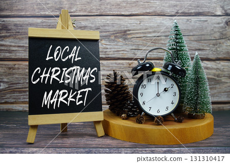 Local Christmas Market  written on easel with vintage alarm clock, pinecones, and miniature Christmas trees 131310417