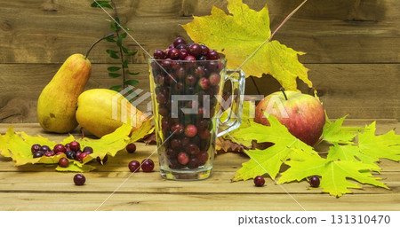 Autumn Still Life. Cranberries in a glass with autumn leaves, apples and pears. Autumn Still Life. Cranberries in a glass with autumn leaves, apples and pears. 131310470