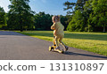 Child scooter riding. Girl yellow scooter park. Motion day lifestyle travel. 131310897