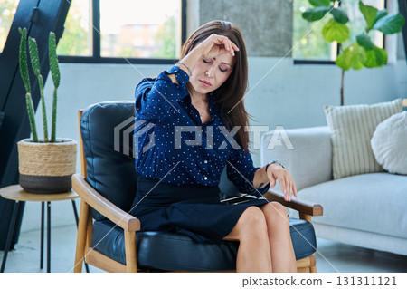 Mature sad woman experiencing stress, headache, mental pain, sitting in chair 131311121