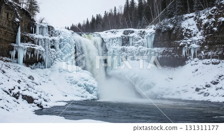 A waterfall flows surrounded by snow and rocks. 131311177
