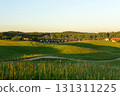 country houses, living in a small village surrounded by nature. summer landscape in a field at sunset. 131311225