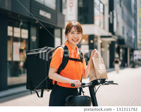 微笑的女性送貨員送貨：城市食品服務 131311782