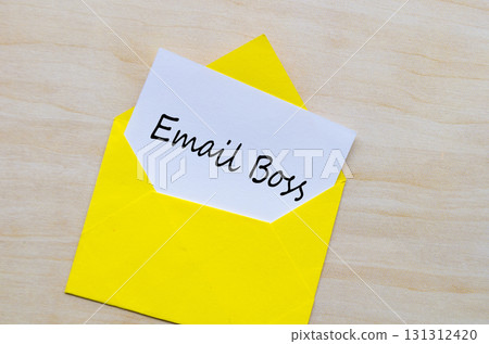 Email Boss text printed on white paper inside empty yellow envelope on wooden surface. Email Boss text printed on white paper inside empty yellow envelope on wooden surface. 131312420